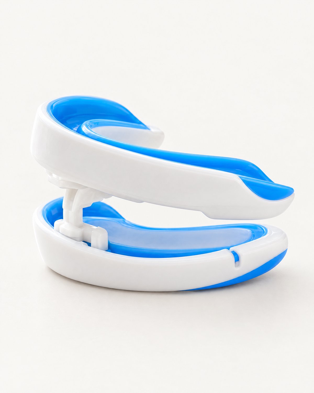 The mouthguard seen from the side, its upper tray above its lower tray, joined by a small connector.